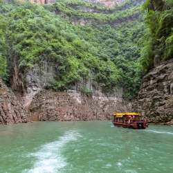 Motoring up a Yangtze tributary defined by steep cliffs above.